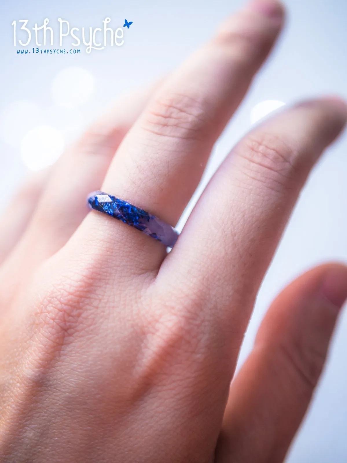 Light blue faceted resin ring with blue flakes