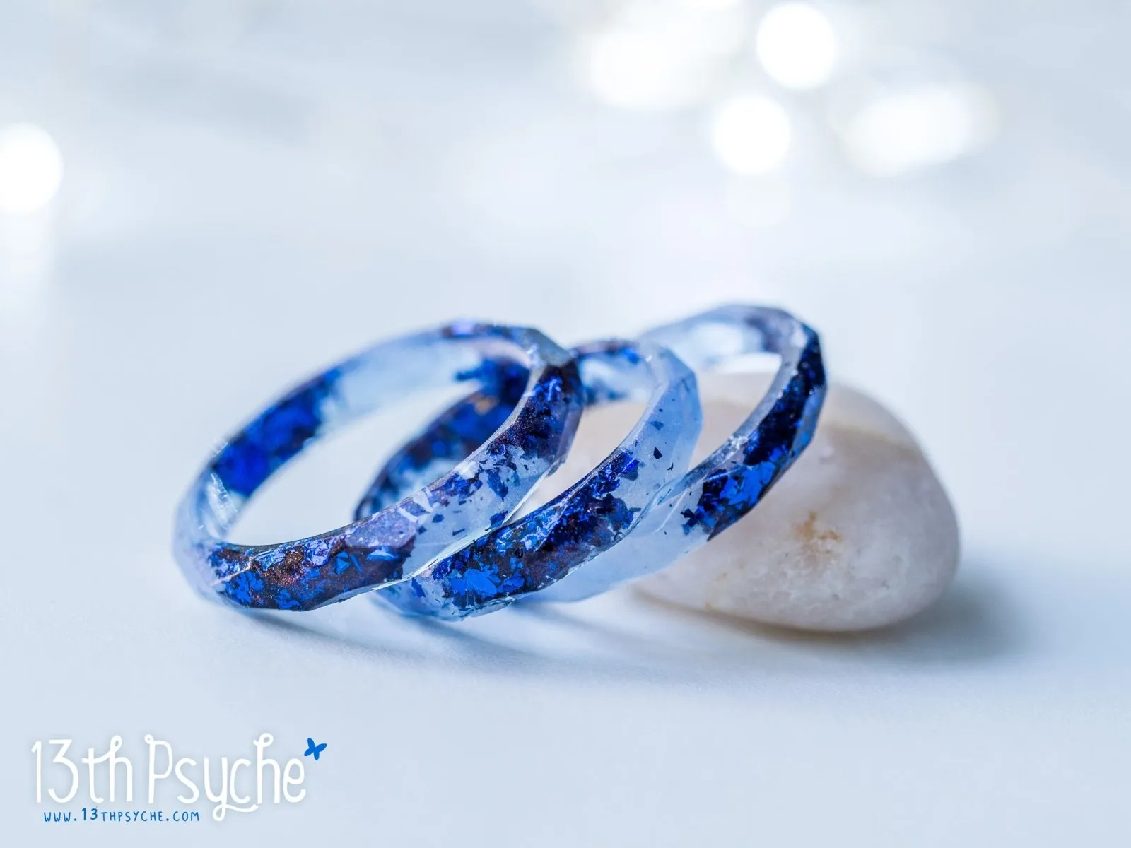 Light blue faceted resin ring with blue flakes